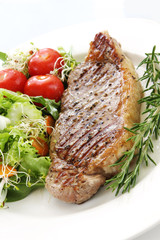 Grilled steak and salad, on white plate.  