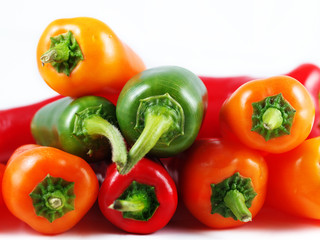 Mixed sweet and chilli peppers over white background