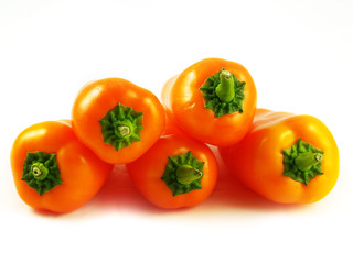 Pile of orange sweet peppers over white background