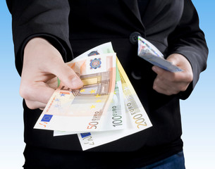 Hand passing Euro banknotes of 50, 100 and 200 Euros.