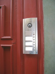 Vidéophone argenté sur porte bordeaux