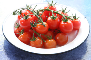 Cherry tomatoes, fresh-picked, in old enamel bowl.