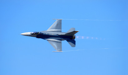 F-14 reaching supersonic speed against a pure blue sky