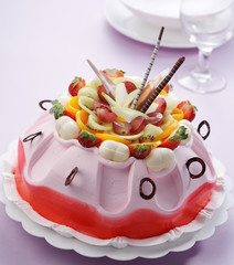 pink color cake with many cut fruits