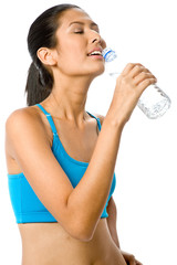 A sporty woman drinking from a water bottle in workout gear 