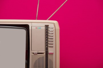 Obraz premium Detail of an old vintage tv set against pink wall