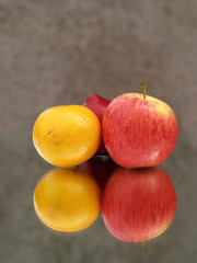Apple and orange reflected in mirror  