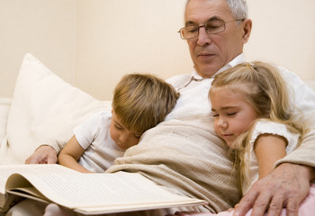 Grandpa is reading book to his grandchild  