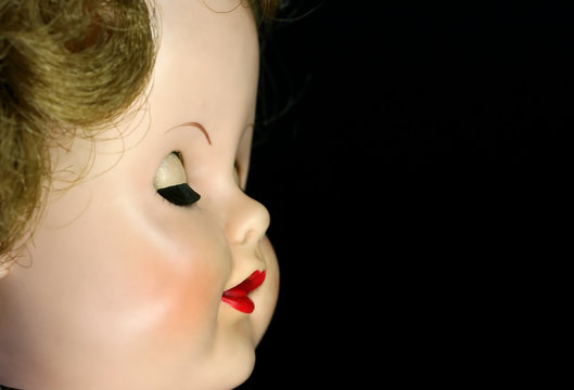 A close up of an antique doll with her eyes closed