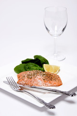 Salmon fillet with herbs macro with spinach and lemon wedge