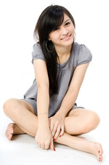 A cute Asian teenager sitting on white background