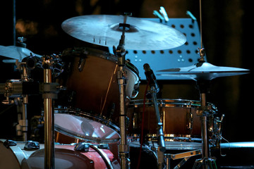 Plakat drum kit on the stage, concert of searchlights