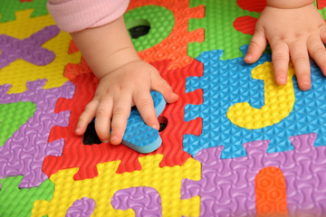 child playing multi colored alphabet puzzle