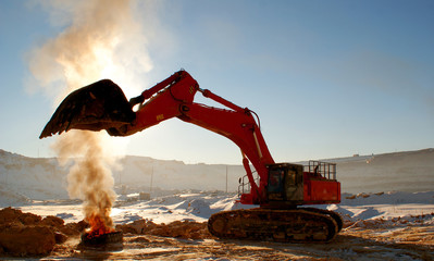 Ladle of a loader heat above a burning tire cover