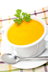 Carrots puree and parsley on white cup over a mat. Shallow DOF