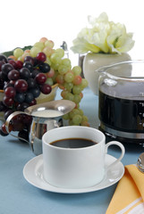 Obraz na płótnie Canvas A cup of coffee on a table with fruit