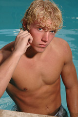 A handsome young man leaning on the edge of the pool