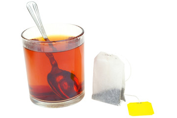 Black tea bags in pack isolated on white and glass.