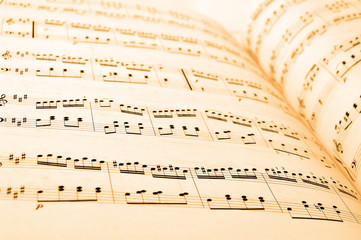 Close-up of sheet music in yellow lighting