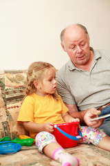 Grandpa and grand-daughter reading 