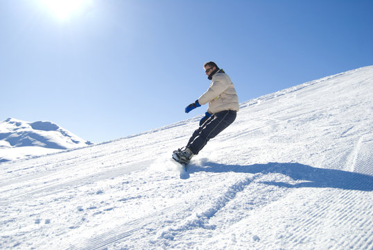 Snowboarder having fun in a bright sunny day stock photo
