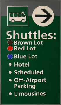 Green Airport Shuttle Sign telling which way to go