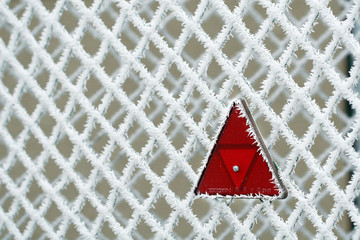 Frosty fence with red triangle - winter texture