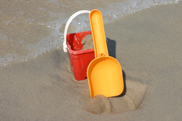 Fototapeta na wymiar Toy bucket and shovel on the beach, plenty of copy space