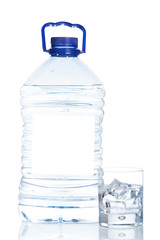 Bottle and glass of mineral water reflected on white background