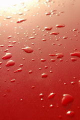 sunrise on metallic vehicle panel rain droplets