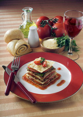 Lasagna with tomatos, olive oil and a glass of wine 