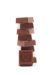 stack of delicious chocolates with heart isolated on white