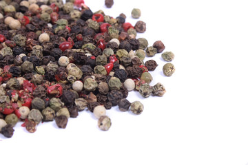 green, black, white and red pepper on the white background
