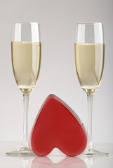two glasses of champagne with red heart in the middle