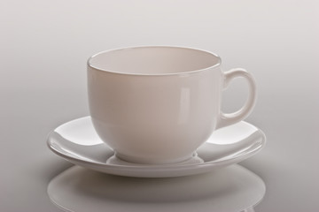 still life, empty white cup over light background