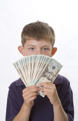 Young boy holding a fan of cash in front of his face