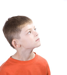 Young boy with a contemplative expression looking up.