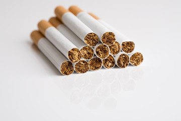Pile of unlit cigarettes with reflection