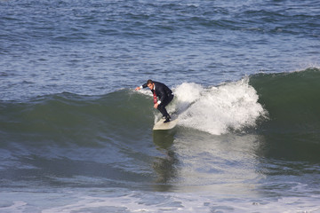 homme en smoking entrain de surfer