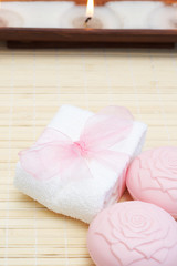Relaxing spa scene with white face towel, pink beauty soap 