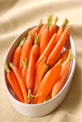 A serving dish filled with fresh organic baby carrots