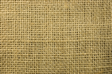 Textured background of a sandy brown burlap cloth