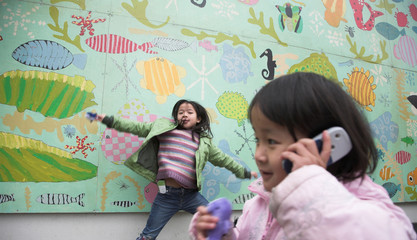  happy child outdoor jumping against a decorated wall