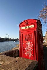 London telephone booth along the Thames, sprayed with graffiti