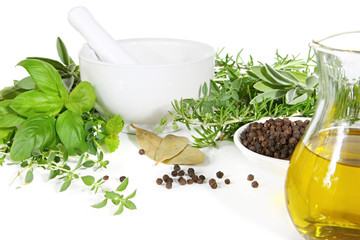 Mortar and pestle with fresh herbs and spices.