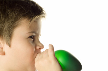 Boy inflates a green balloon