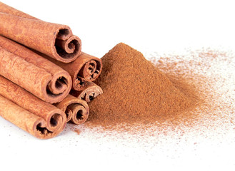 Cinnamon powder and cinnamon sticks on a white background