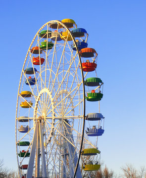 Big colorful ferris wheel over blue sky