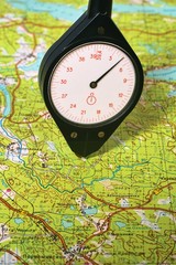 Old plastic curvimeter measures the way on the topographic map.