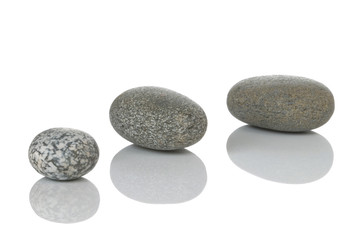 Three pebbles with reflections, isolated on white.